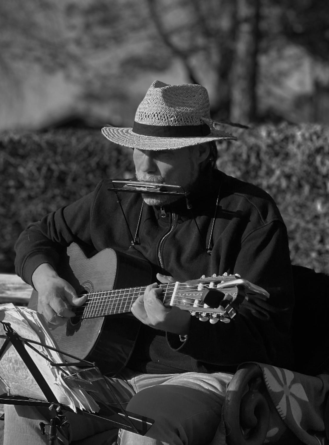 Helmut Jenne spielt im Freien Gitarre und Mundharmonika